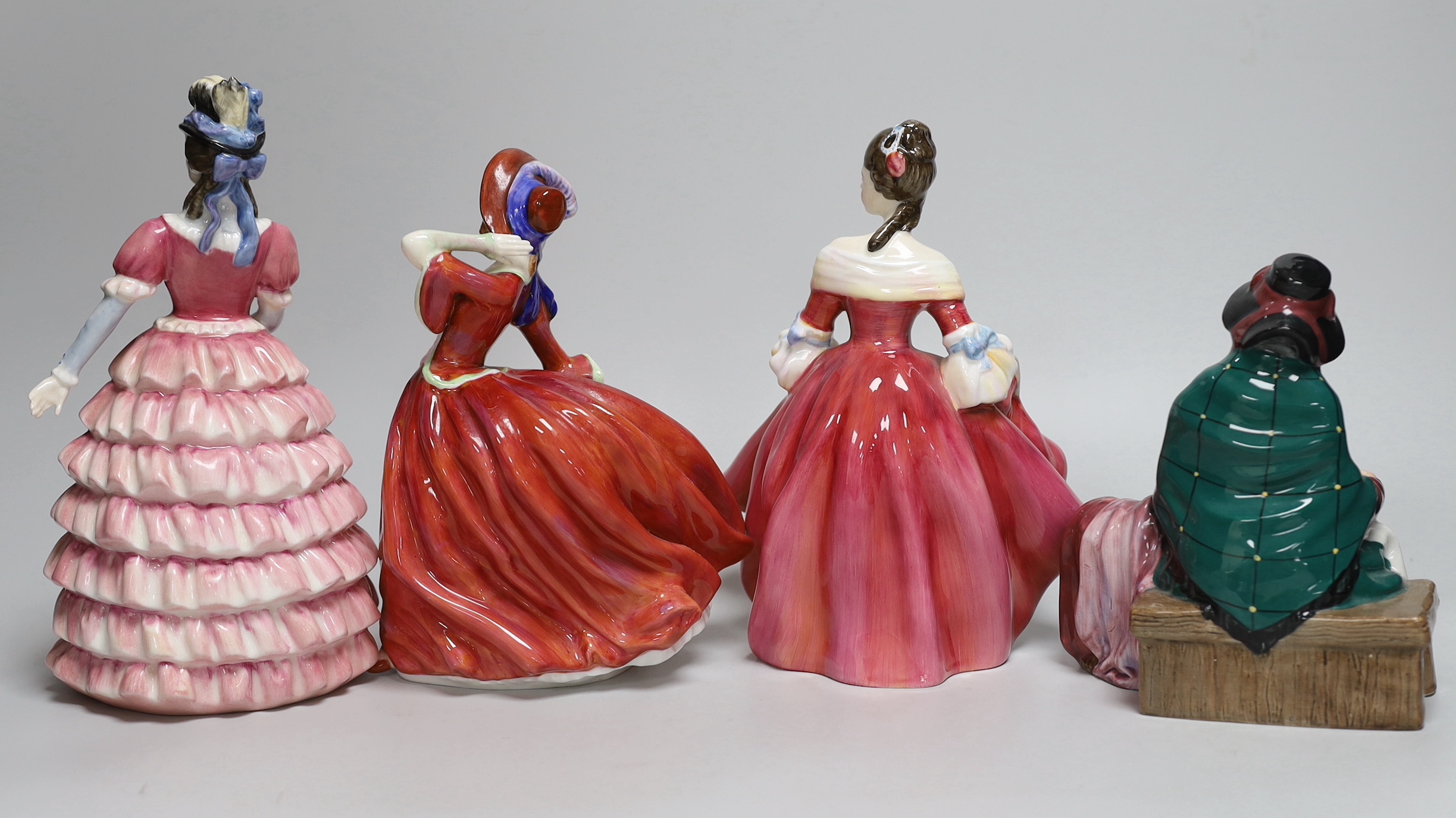 Four Royal Doulton figurines including Autumn Breezes and an oversized Christian Dior advertising scent bottle, Eau Sauvage Extreme, the largest 33cm high